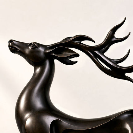 Open-form bronze body and integrated base detail on the leaping deer sculpture