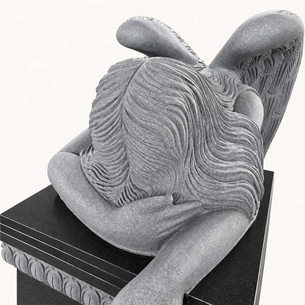 Close-up of carved hair and folded arms on the weeping angel headstone