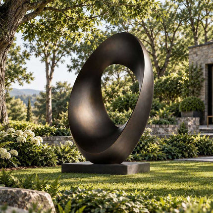 Abstract bronze ring sculpture displayed in a landscaped residential garden