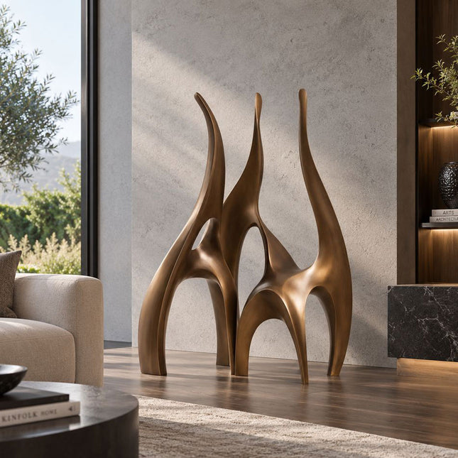 Abstract bronze sculpture with flowing arched forms displayed in a modern living room