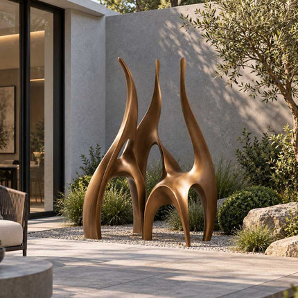 Contemporary bronze sculpture with three rising forms displayed in a private garden courtyard