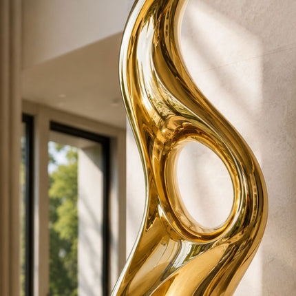 Reflective gold surface and circular opening detail on abstract sculpture
