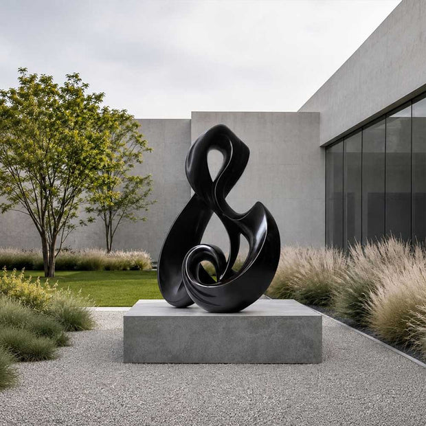 Abstract stainless steel sculpture installed in an architectural landscape