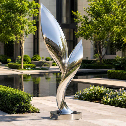 Mirror polished abstract stainless steel sculpture displayed in a contemporary outdoor landscape