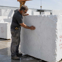 An experienced artisan selecting a Guangxi White marble block for a custom handcrafted marble sculpture.