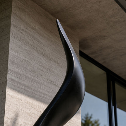 Detail view of the refined edge and flowing contours of a black stainless steel sculpture