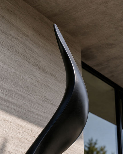Detail view of the refined edge and flowing contours of a black stainless steel sculpture