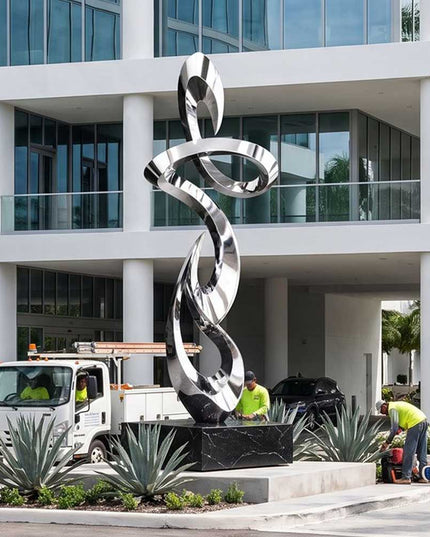 Large stainless steel abstract sculpture installed at a contemporary architectural entrance