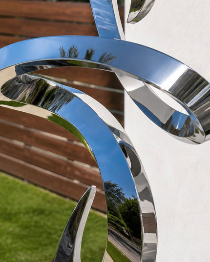Detailed view of reflective surface and flowing form of stainless steel sculpture