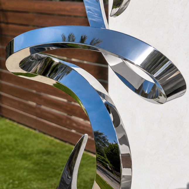 Detailed view of reflective surface and flowing form of stainless steel sculpture