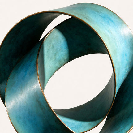 Close-up of broad curved bronze bands forming an open circular loop with blue-green patina