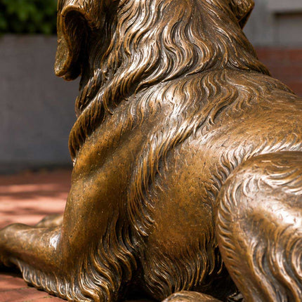 Detailed handcrafted bronze dog sculpture showing textured fur and patina finish