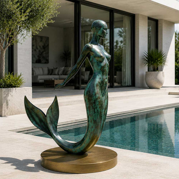 Bronze mermaid sculpture installed beside a modern pool courtyard
