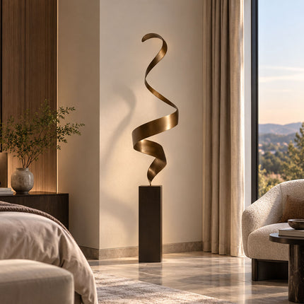 Slender bronze ribbon sculpture with a vertical spiral form displayed in a contemporary bedroom