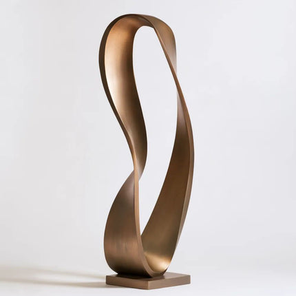 Bronze ribbon sculpture with an elongated flowing loop and open center