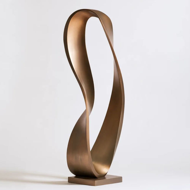 Bronze ribbon sculpture with an elongated flowing loop and open center