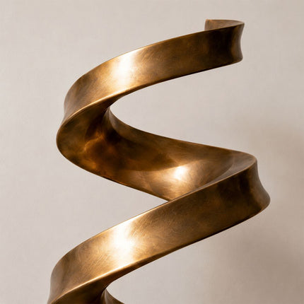 Close-up of broad twisting bronze surfaces with warm highlights and subtle texture