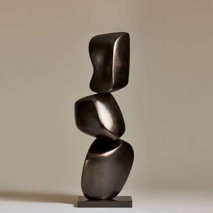 Bronze sculpture art with three rounded forms balanced vertically on a rectangular base