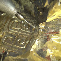 Craftsman refining fine details and welded seams on a handcrafted bronze sculpture