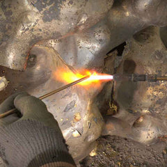 Craftsman refining welded joints on a handmade bronze sculpture