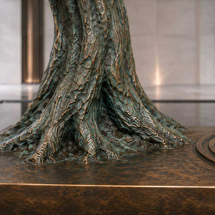 Textured bronze tree trunk with green patina and warm bronze highlights