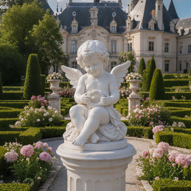 White seated cherub angel statue displayed on a tall pedestal in a formal garden