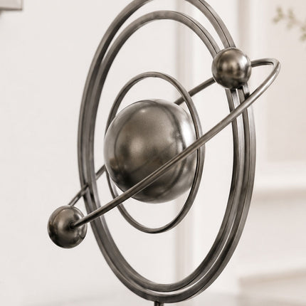 Detail view of contemporary stainless steel sculpture featuring orbital inspired metal rings