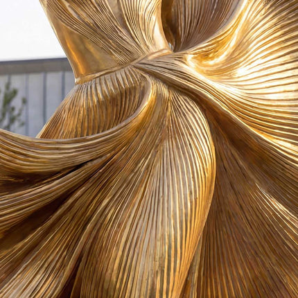 Detailed view of handcrafted stainless steel female sculpture with gold metallic finish