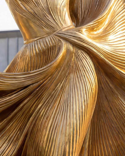 Detailed view of handcrafted stainless steel female sculpture with gold metallic finish