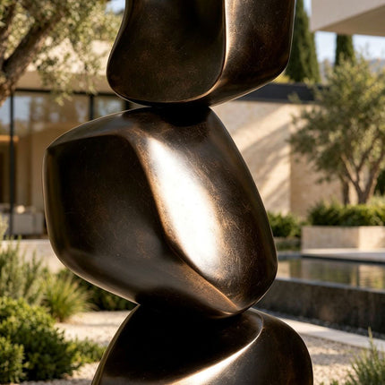 Close-up of rounded bronze forms with dark patina and warm highlighted edges