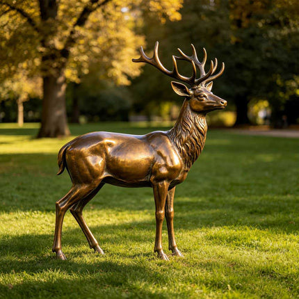 Bronze deer statue displayed on a lawn in a landscaped outdoor garden