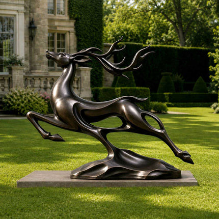 Bronze deer sculpture with flowing antlers displayed in a landscaped estate garden
