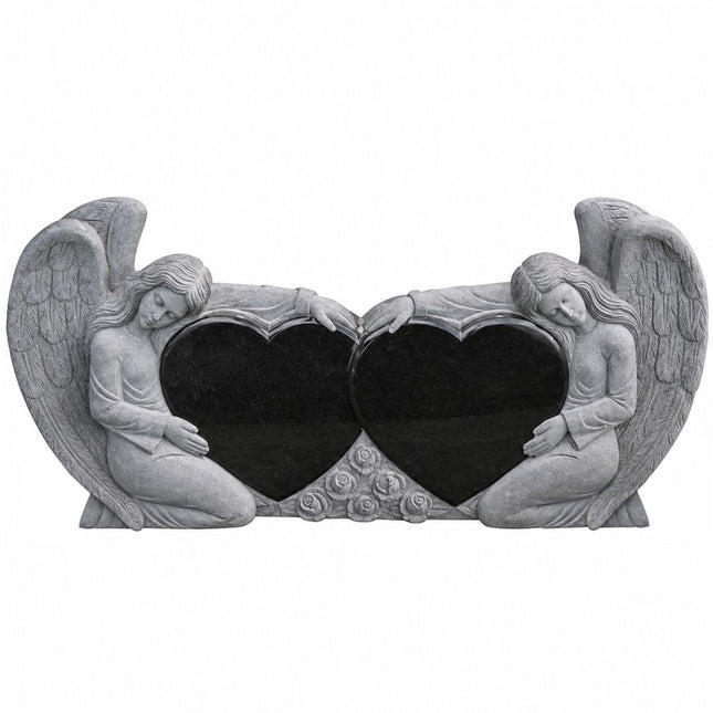Black granite double heart headstone framed by two carved angels and feathered wings