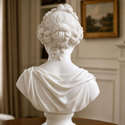 Back view of a female marble bust showing carved hair and flowing drapery