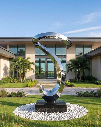 Contemporary stainless steel abstract sculpture displayed in a landscaped garden setting