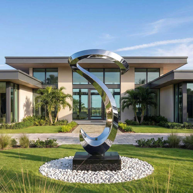 Contemporary stainless steel abstract sculpture displayed in a landscaped garden setting