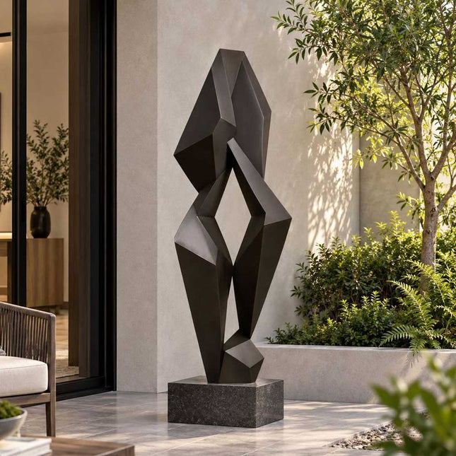 Geometric abstract bronze sculpture with faceted forms in a modern residential courtyard