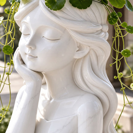 Side view of a white girl head planter showing sculpted flowing hair, a closed-eye expression, and trailing plants