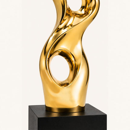 Lower circular opening and black base detail of gold abstract sculpture