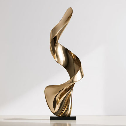 Gold abstract stainless steel sculpture with a tall twisting ribbon form and black rectangular base