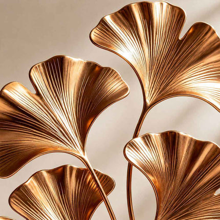 Close detail of gold electroplated stainless steel surface and sculpted leaf texture