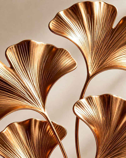 Close detail of gold electroplated stainless steel surface and sculpted leaf texture