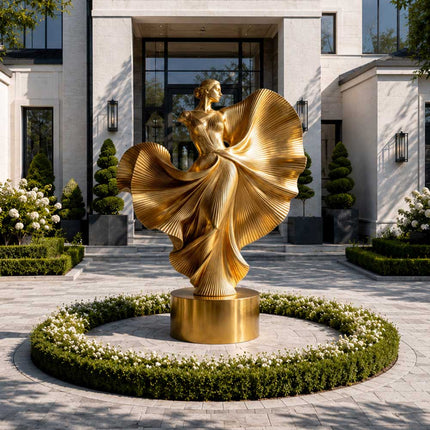 Gold stainless steel female figure sculpture displayed in a luxury residential entrance garden