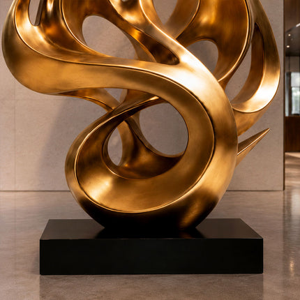 Close view of gold stainless steel sculpture surface and flowing curved details