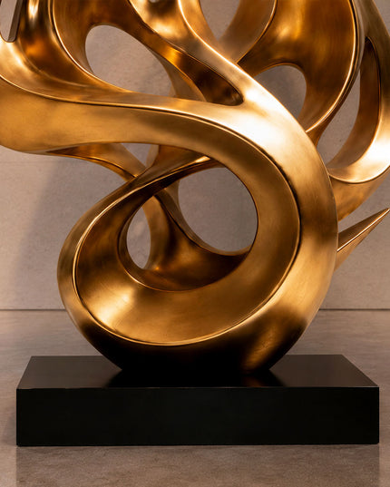 Close view of gold stainless steel sculpture surface and flowing curved details
