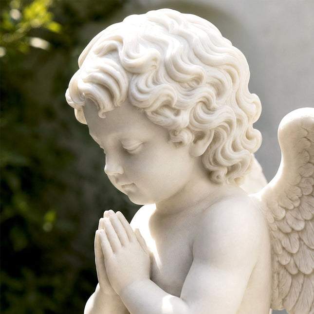 Close-up view of a marble angel sculpture showing facial details and hand-carved features