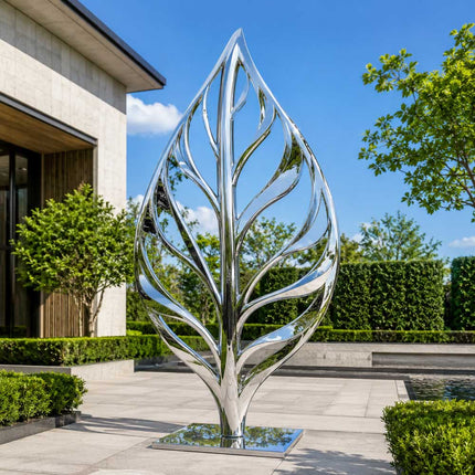 Mirror polished stainless steel leaf inspired sculpture installed in a contemporary garden