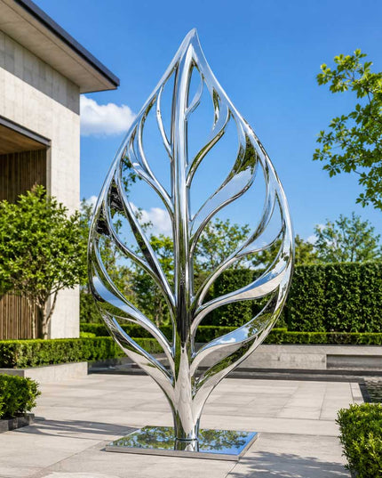 Mirror polished stainless steel leaf inspired sculpture installed in a contemporary garden