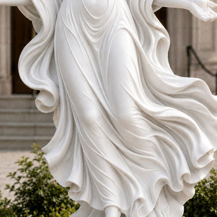 Detailed marble carving of flowing robes on a winged angel sculpture