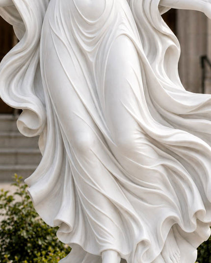 Detailed marble carving of flowing robes on a winged angel sculpture